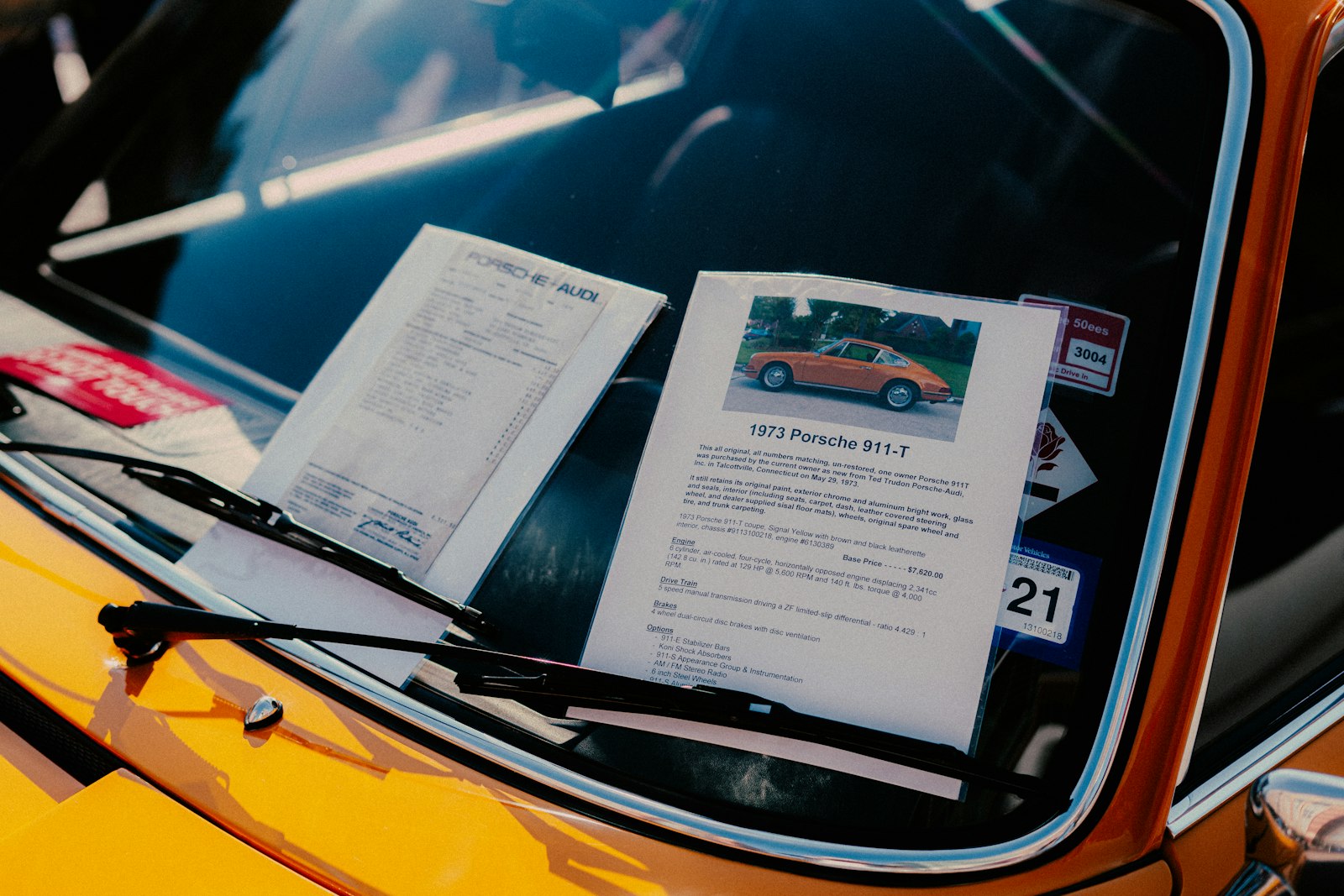 Originalunterlagen und Datenblatt eines Porsche 911 T von 1973 hinter der Windschutzscheibe