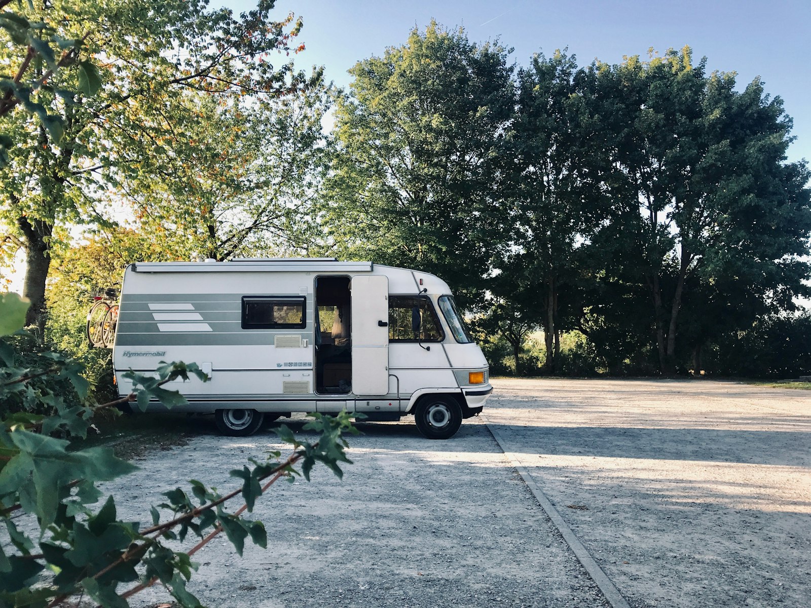 Teilintegriertes Reisemobil auf einem Stellplatz am Waldrand